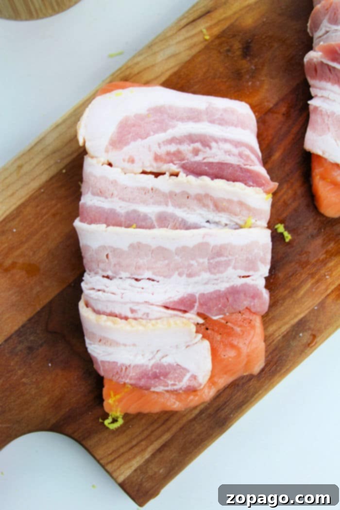 Crispy Bacon Wrapped Salmon 4 Bacon wrapped salmon fillet on a white plate, gently sprinkled with brown sugar for a sweet and savory finish.
