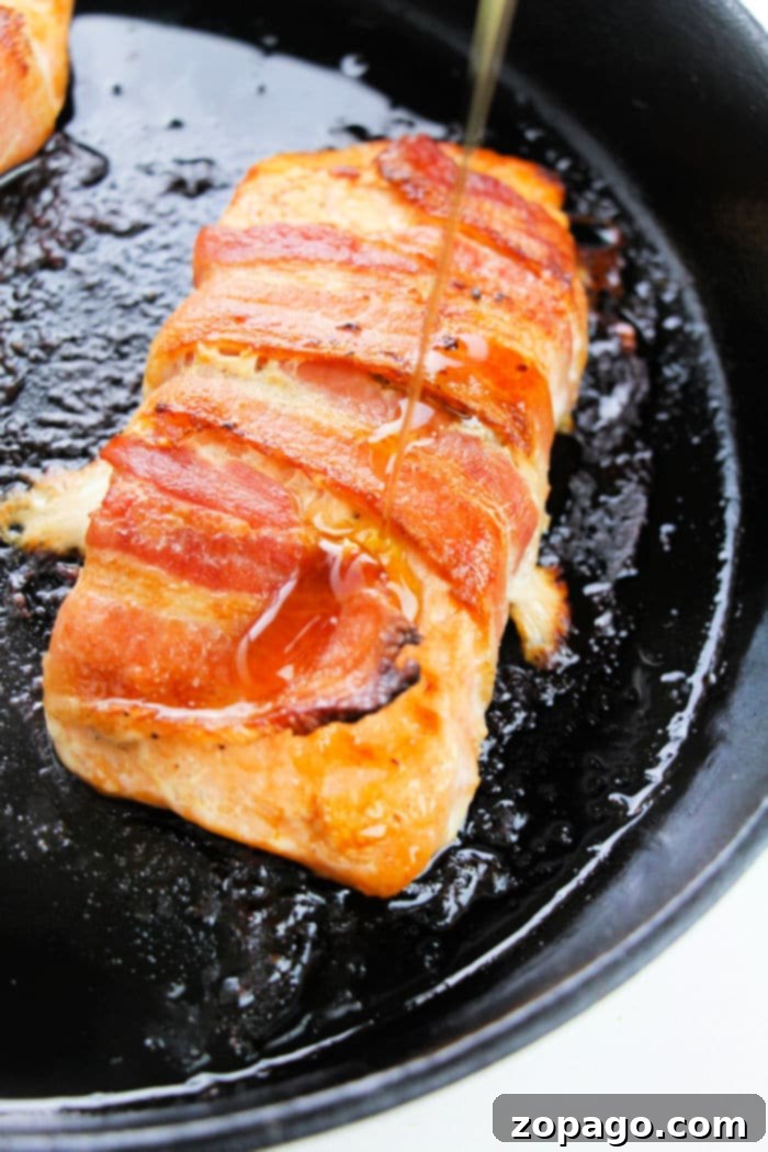 Crispy Bacon Wrapped Salmon 7 Perfectly seared salmon fillet inside a well-seasoned cast iron skillet, demonstrating the ideal crust and cooking method.