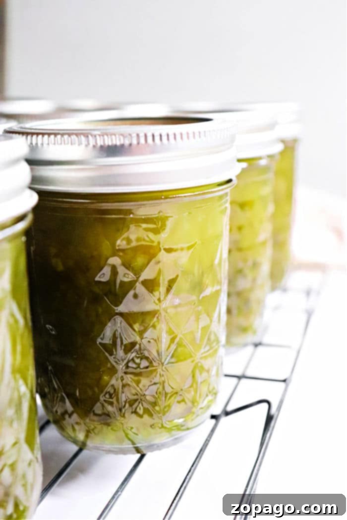Sweet Heat Pepper Jelly 2 Sealed jars of homemade green pepper jelly cooling on a rack, ready for storage.