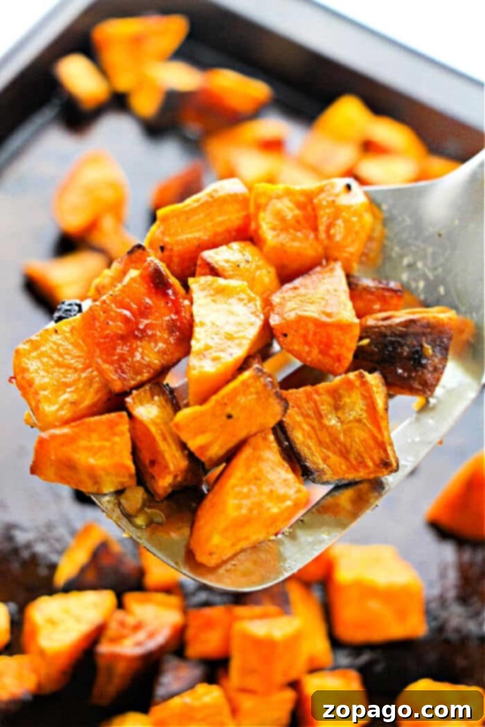 Oven-Roasted Sweet Potato Cubes 2 Crispy roasted sweet potato cubes on a baking sheet, ready to be served.