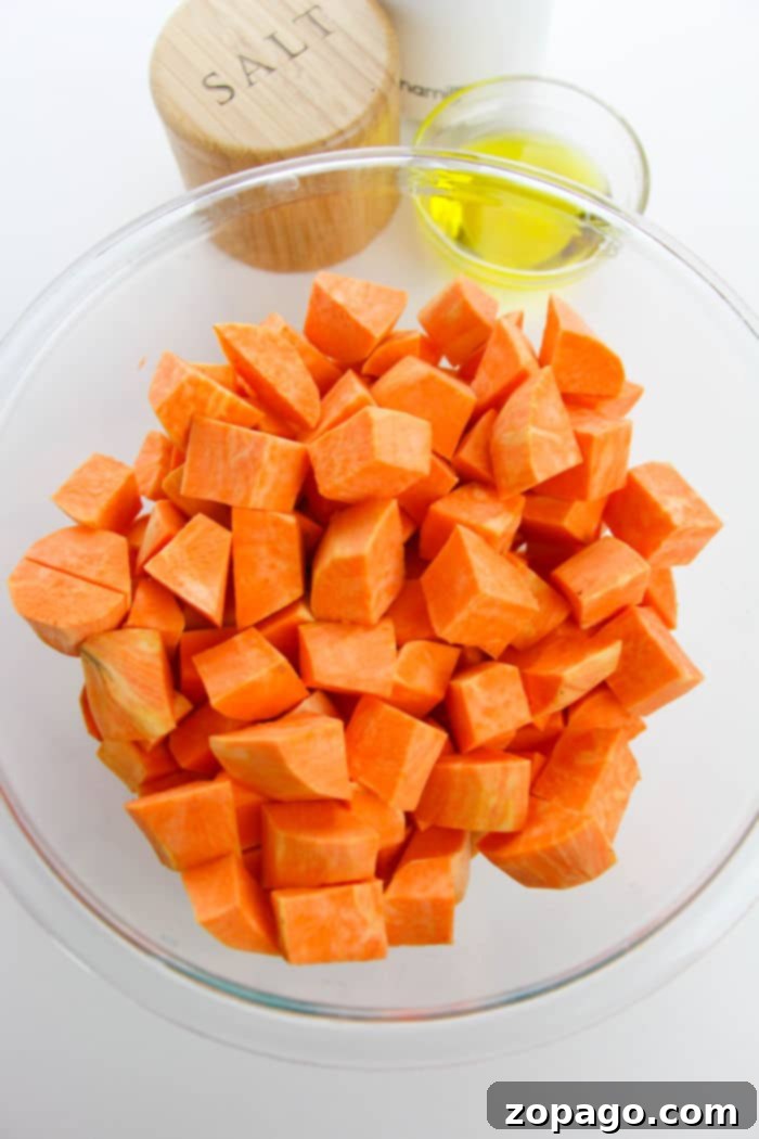 Oven-Roasted Sweet Potato Cubes 4 Close-up of golden-brown sweet potato cubes on a baking sheet, with some perfectly caramelized edges.