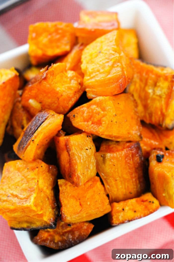 Oven-Roasted Sweet Potato Cubes 6 A close-up of beautifully roasted sweet potato cubes, garnished and ready for serving in a bowl.