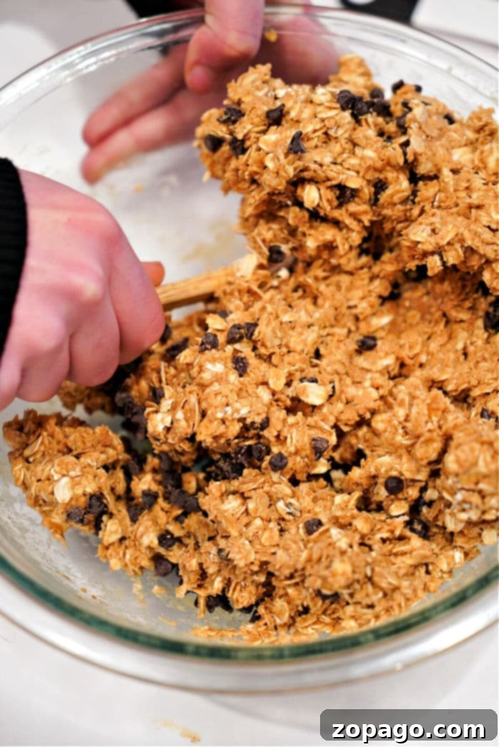 Viral TikTok Oatmeal Bars 5 Freshly drizzled chocolate peanut butter bars on parchment paper, ready to be frozen.