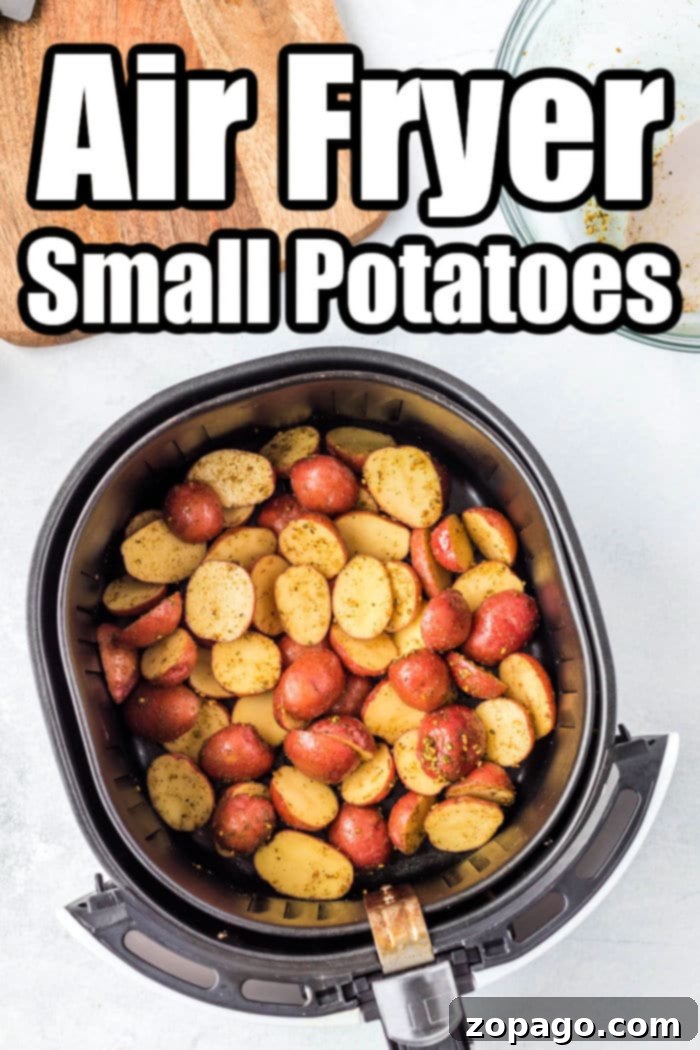 A close-up view of halved baby potatoes tossed with olive oil and spices in a bowl, ready for the air fryer.