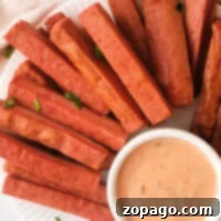 Crispy Air Fryer Spam Fries 8 A plate of crispy Spam Fries served with a small bowl of creamy dipping sauce, garnished with chopped herbs.