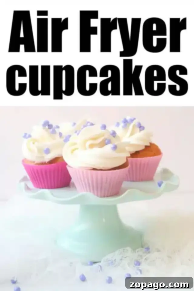 Easy Air Fryer Cupcakes 7 A charming display of three Air Fryer cupcakes with fluffy white frosting and sparkling purple sprinkles, arranged on a light blue cake stand. The cupcakes are nestled in cheerful pink wrappers. The text above proudly declares "Air Fryer Cupcakes."
