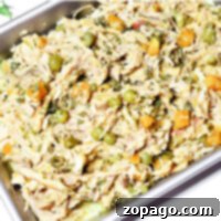 Easy Crockpot Chicken Dog Meals 8 A crockpot dog food delight: a tray of shredded chicken with peas, carrots, and herbs, cooked to perfection.