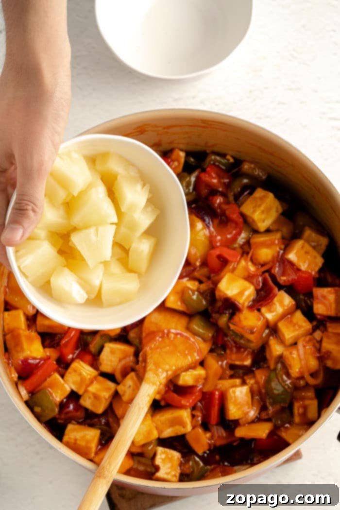 Tangy Tofu Wok Toss 5 A colorful sweet and sour tofu dish with vegetables and pineapple, garnished with green onions