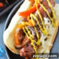 A delicious baked sausage topped with peppers, onions, sauerkraut, and mustard in a bun awaits you on a plate. If you're curious about how to cook bratwurst in the oven for this flavorful experience, you're just a few steps away from perfection.