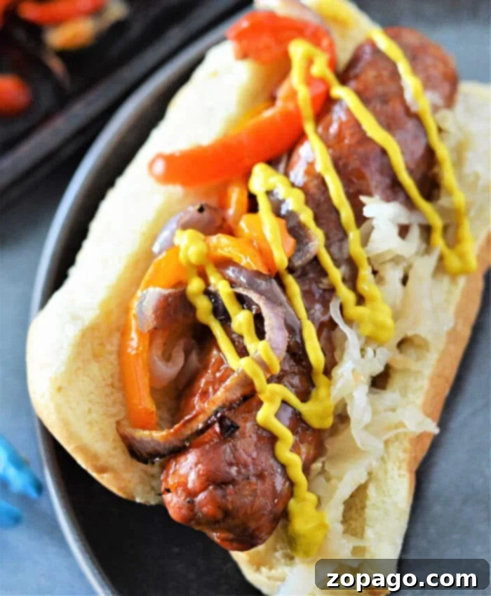 Roasted Bratwurst Perfection 8 Cooked brats with roasted peppers and onions on a sheet pan.