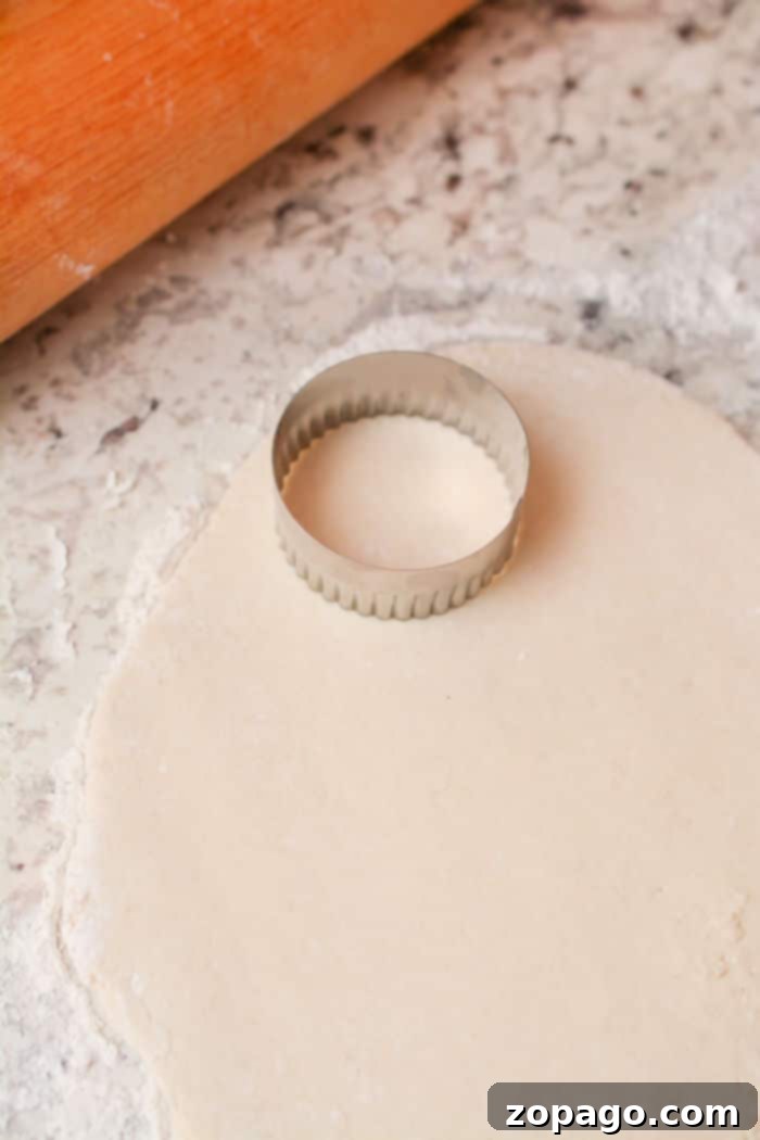 Fluffy Bisquick Biscuits Every Time 6 A freshly cut, unbaked Bisquick biscuit dough on a floured surface, ready for baking, illustrating the importance of pressing without twisting the cutter.