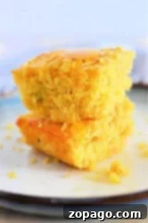 Two pieces of Jiffy Mexican Cornbread stacked on a plate, drizzled with honey.