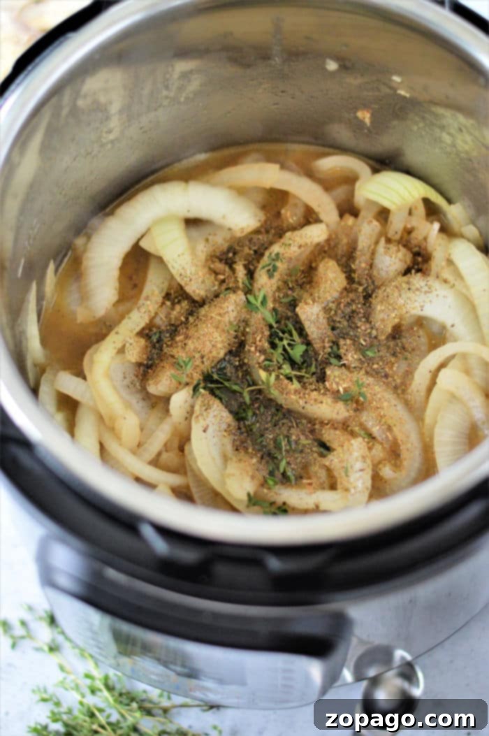 Easy Instant Pot French Onion Chicken 6 onions and chicken in instant pot, simmering to perfection