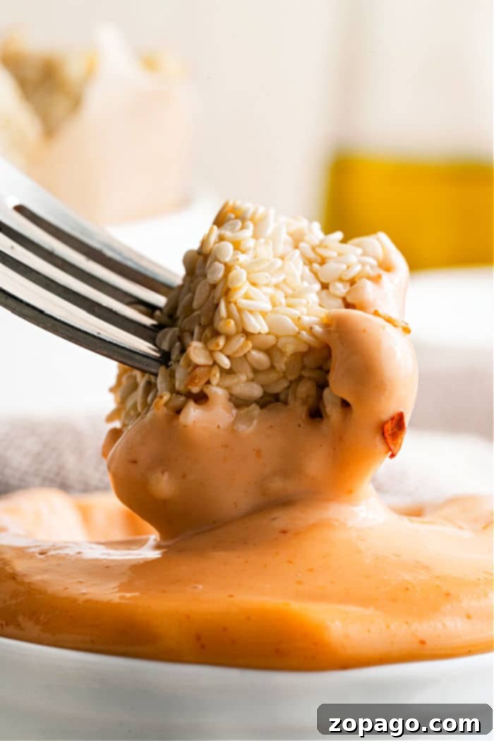 Whip Up Zesty Sriracha Mayo 2 Homemade Sriracha Mayo, a vibrant red sauce in a small white bowl, ready to elevate any dish.