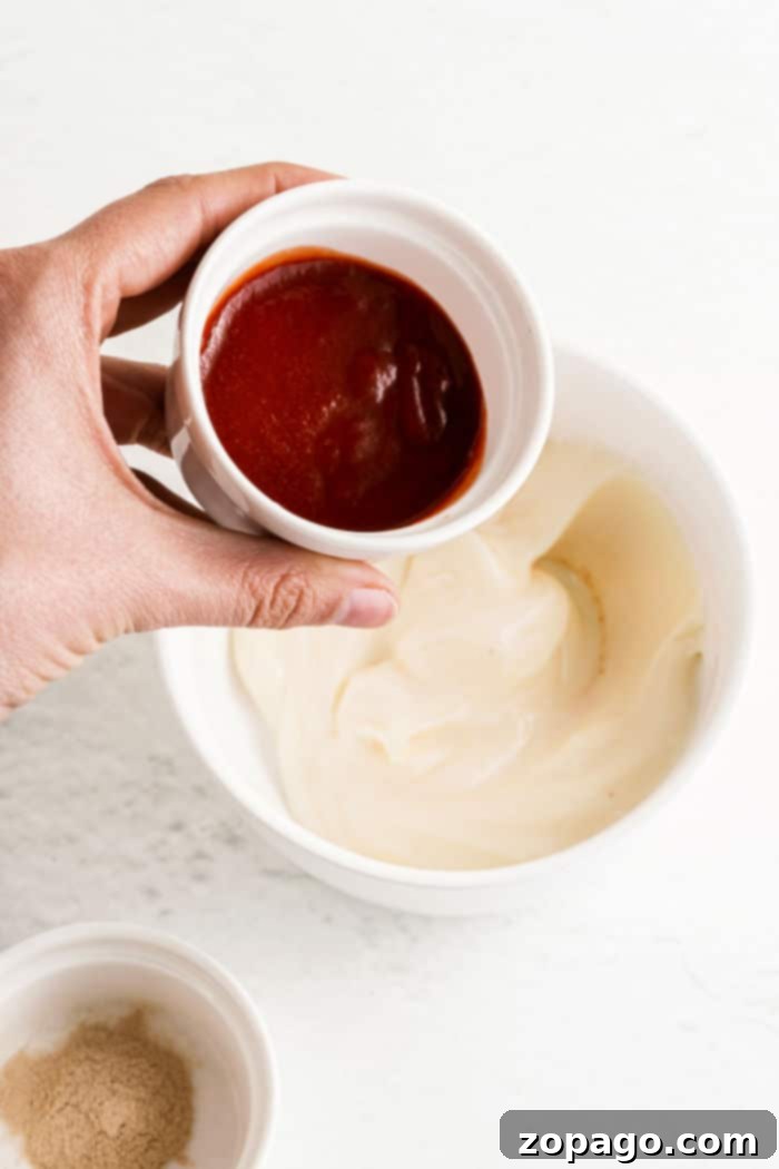 Whip Up Zesty Sriracha Mayo 4 A small bowl of creamy, orange Sriracha mayo, ready to be served as a versatile dipping sauce.