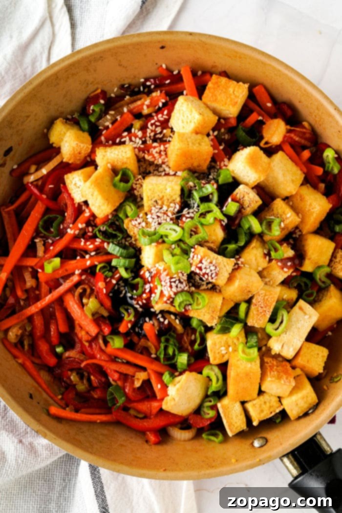 Sweet & Savory Teriyaki Tofu Lettuce Wraps 5 A skillet with tofu cubes, green onions, sesame seeds, mixed vegetables, and a touch of tofu for that lettuce wrap vibe.