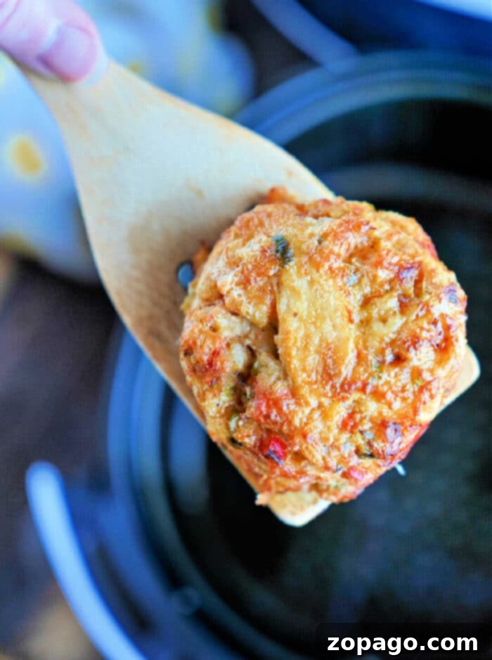 Crispy Air Fryer Frozen Crab Cakes 2 Air fryer basket with two perfectly cooked frozen crab cakes, showcasing their golden-brown, crispy exterior.