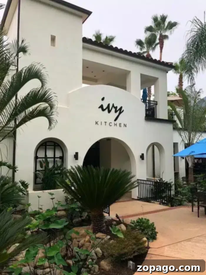 Unbeatable Glen Ivy Corona Deals 3 The charming Ivy Kitchen building at Glen Ivy Hot Springs, offering delicious dining options amidst lush gardens and palm trees, an ideal spot to relax and refuel during your spa day.