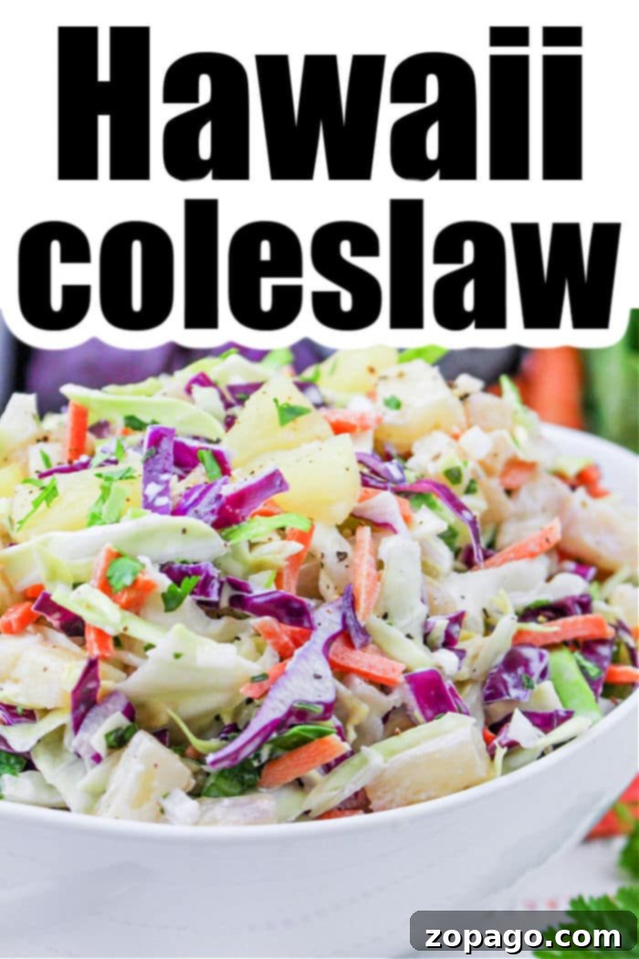 Creamy Hawaiian Pineapple Slaw 6 A large bowl of colorful Hawaiian coleslaw, with green and purple cabbage, carrots, pineapple, and fresh herbs, ready to serve.