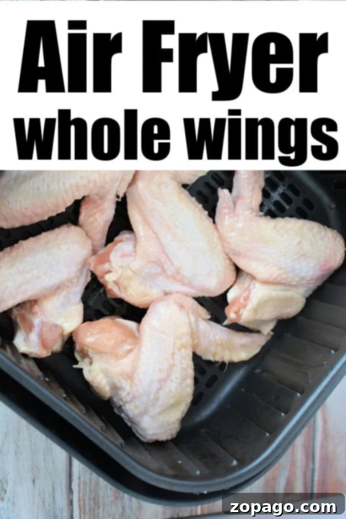 Crispy Air Fryer Whole Chicken Wings 4 Air fryer basket filled with seasoned, raw whole chicken wings ready for cooking.