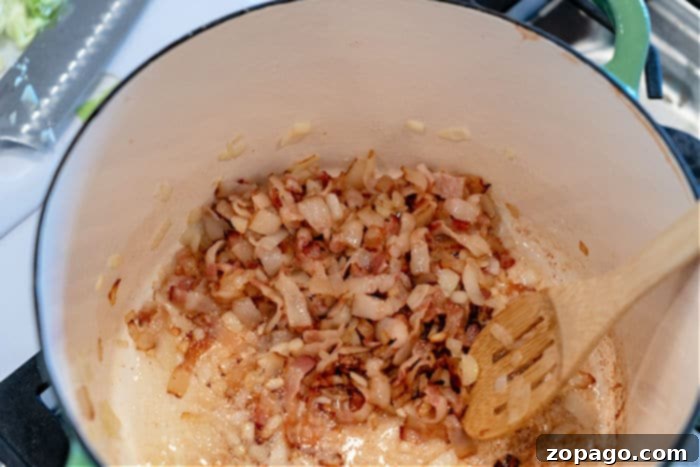 Golden Southern Skillet Cabbage 5 Close-up of sizzling bacon and onions sautéing in a pan, a foundational step for many savory dishes.