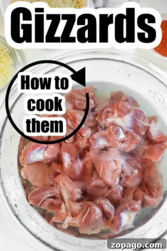 Golden Crispy Air Fryer Chicken Gizzards 4 A glass bowl filled with raw chicken gizzards soaking in water.