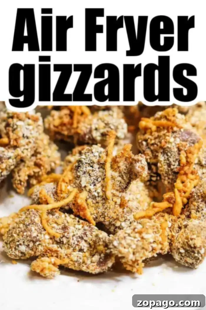 Golden Crispy Air Fryer Chicken Gizzards 9 Close-up image of fried chicken gizzards covered in a light breading on a white surface, with the text "Air Fryer Chicken Gizzards" in bold black letters at the top. The gizzards appear crispy and seasoned.