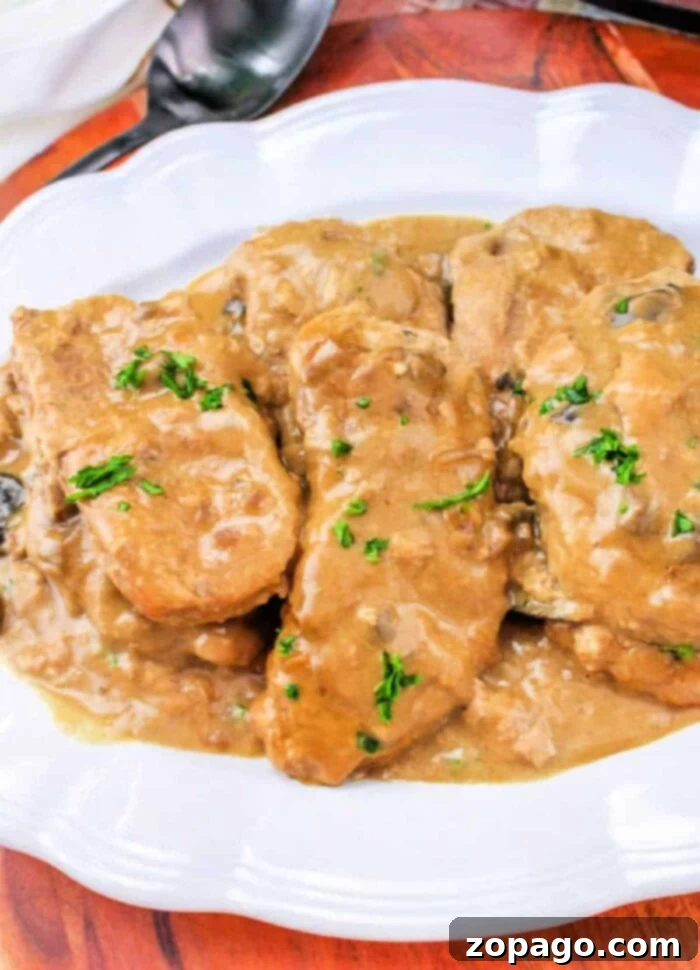 Succulent Slow Cooker Pork Chops with Velvety Gravy 2 Tender Boneless Pork Chops in Slow Cooker with creamy gravy