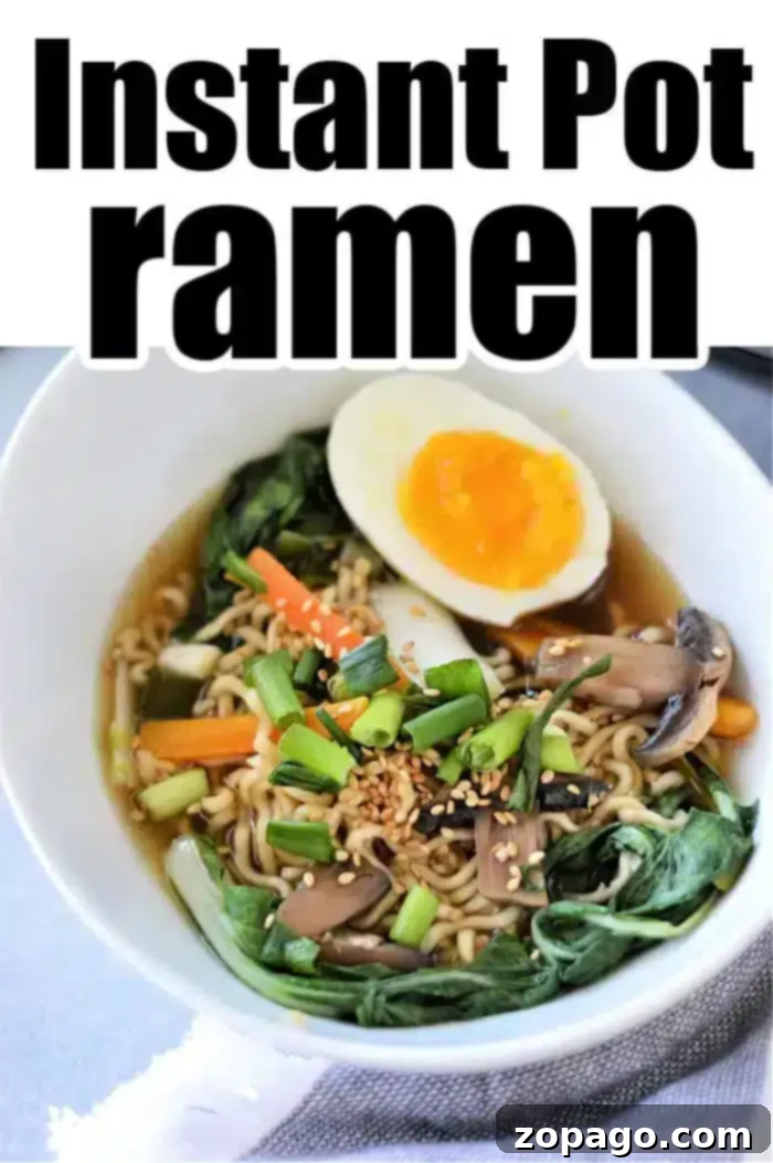Perfect Instant Pot Ramen 2 A vibrant bowl of Instant Pot Vegetable Ramen, beautifully garnished with a halved soft-boiled egg, fresh green onions, sliced mushrooms, shredded carrots, and leafy greens. The dish appears steaming hot and inviting, ready to be enjoyed.