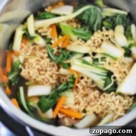 Instant Pot Ramen featuring ramen noodles, bok choy, carrot strips, and savory broth—all ready to be cooked in your Instant Pot.