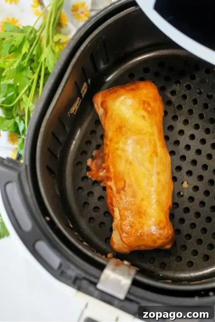 No More Cold Spots Hot Pocket Cook Time Secrets 5 An air-fried burrito in an air fryer basket.