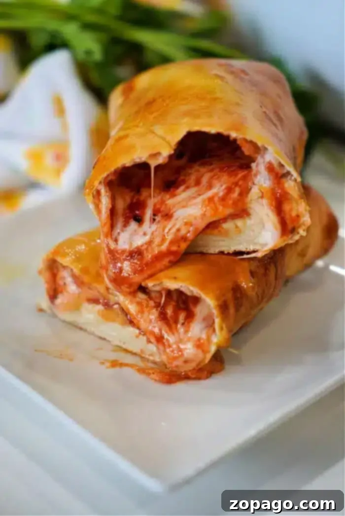 No More Cold Spots Hot Pocket Cook Time Secrets 8 A close-up shot of two slices of stromboli stacked on a white plate.