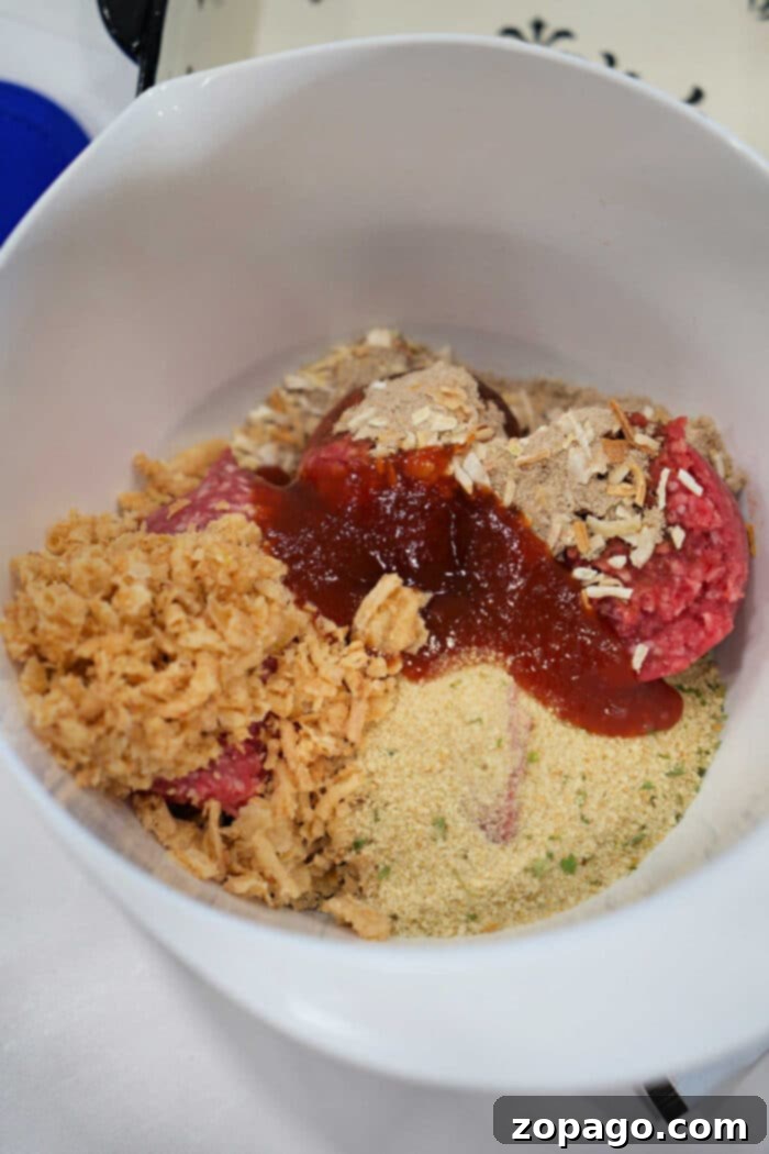 Smoky BBQ Meatloaf Perfection 4 Unmixed meatloaf ingredients in a bowl, including ground beef, breadcrumbs, crushed chips, and sauce—perfect for starting your favorite BBQ meatloaf recipe.