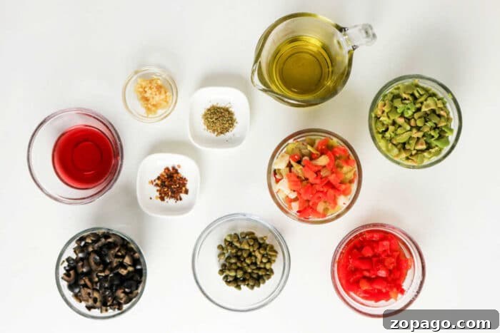 Authentic Muffuletta Olive Salad Recipe for Sandwichs & Platters 3 Various small bowls with chopped vegetables, olives, capers, spices, oil, and vinegar arranged on a white surface—perfect ingredients for a classic Muffuletta recipe or homemade olive salad.