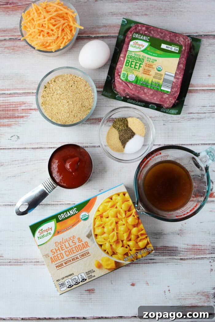 Mac and Cheese Meatloaf Casserole Bake 3 Ingredients for a cheesy casserole, blending pasta, ground beef, cheese, egg, broth, sauce, and seasonings—like a tasty mash-up of cheeseburger and classic mac and cheese.