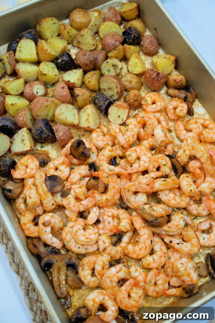 Garlic Butter Shrimp with Crispy Roasted Potatoes 6 Roasted shrimp and potatoes, paired with savory mushrooms, all seasoned to perfection in a rectangular baking pan.