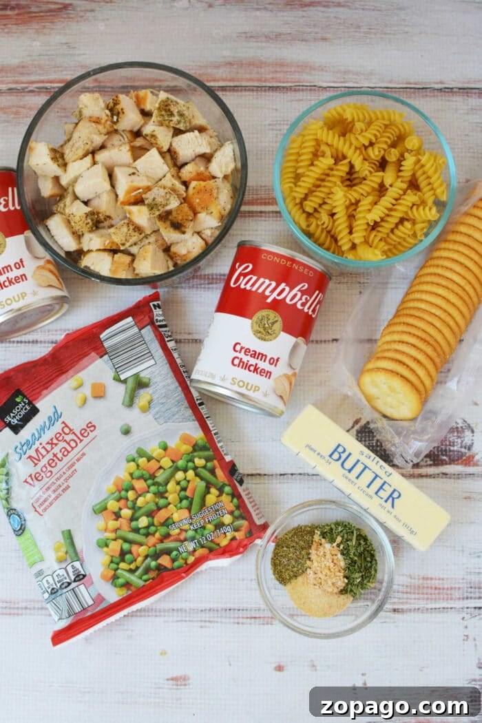Cheesy Ritz Chicken Casserole with Crunchy Cracker Topping 3 Cubed chicken, rotini pasta, canned soup, mixed veggies, crackers, butter, and seasonings are arranged on the table—everything you need to make a classic Ritz Chicken Casserole.
