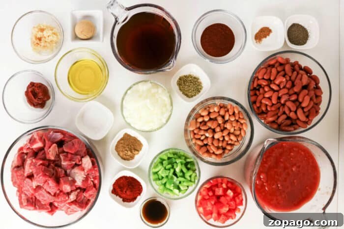 Slow-Simmered Chuck Roast Chili Recipe 3 Bowls of raw beef, beans, diced vegetables, spices, and liquids arranged on a white surface, viewed from above—ingredients perfectly suited for a hearty Chuck Roast Chili.