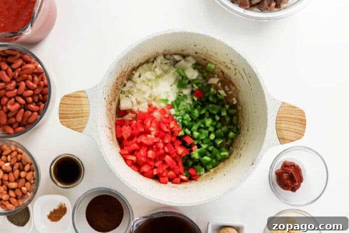 Slow-Simmered Chuck Roast Chili Recipe 4 Diced onions, red bell peppers, and green bell peppers in a pot, surrounded by hearty chili ingredients—perfect for a delicious chuck roast chili or classic beef chili.